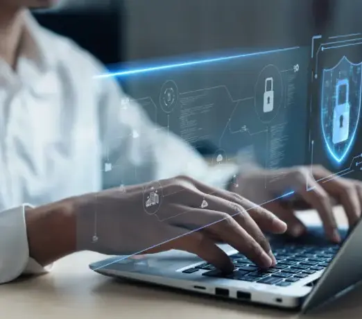 Person arbeitet am Laptop mit Sicherheitssymbol – Umsetzung von DSGVO und Website Sicherheit.