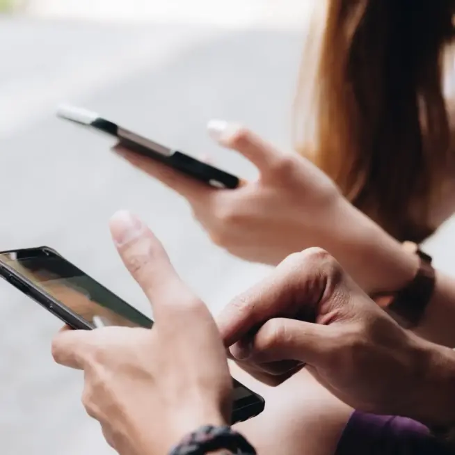 Zwei Personen analysieren Smartphone-Ansicht – mobile Optimierung und schnelle Ladezeiten als Teil unserer Webdesign Leistungen.