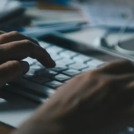 Nahaufnahme von Händen auf einer Tastatur – präzise Umsetzung unserer Webdesign Leistungen.