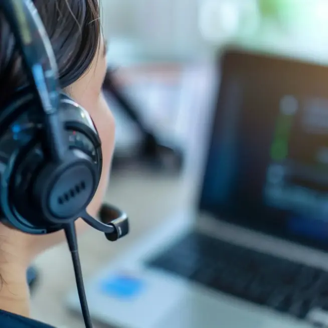 Mitarbeiterin mit Headset am Computer – persönlicher Support als Teil unserer Webdesign Leistungen.
