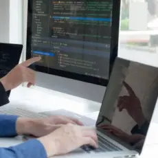 Teamarbeit am Computer mit Code – Zusammenarbeit in unserer Webdesign Agentur.