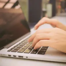 Hände auf Laptop-Tastatur – effiziente und präzise Arbeitsschritte in der Webseiten-Erstellung.