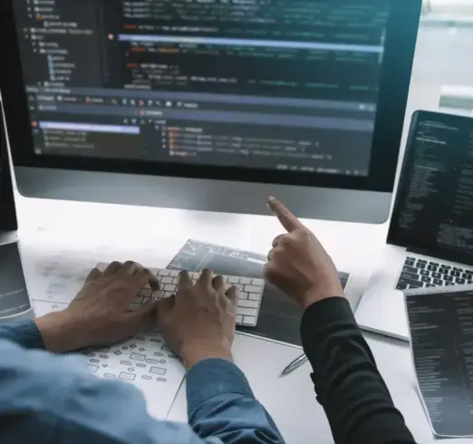 Team analysiert Code am Monitor – präzise Webseiten-Erstellung für Unternehmen.